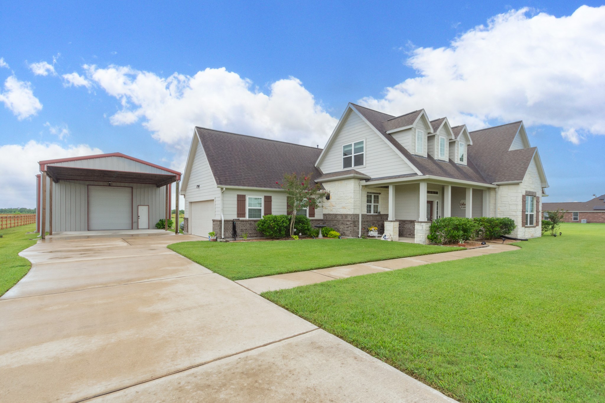 a view of a big yard in front of a brick house with a small yard