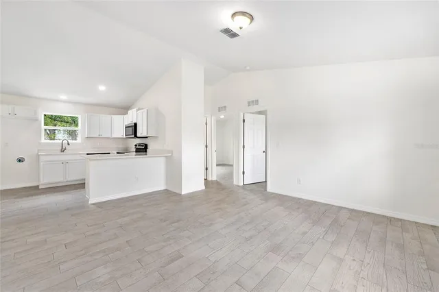 a view of kitchen with wooden floor and electronic appliances