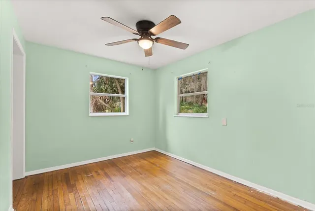 a view of empty room with wooden floor