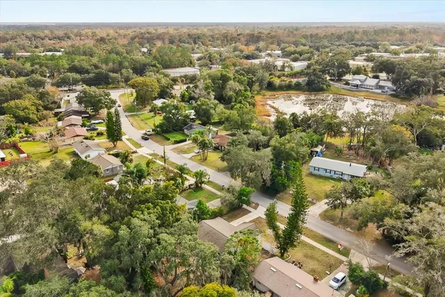 an aerial view of residential house with outdoor space and trees all around
