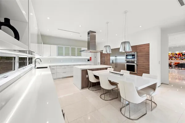 a kitchen with stainless steel appliances kitchen island granite countertop a kitchen island and chairs in it