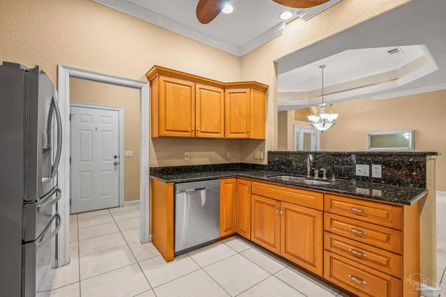 a kitchen with granite countertop cabinets stainless steel appliances a sink and a window