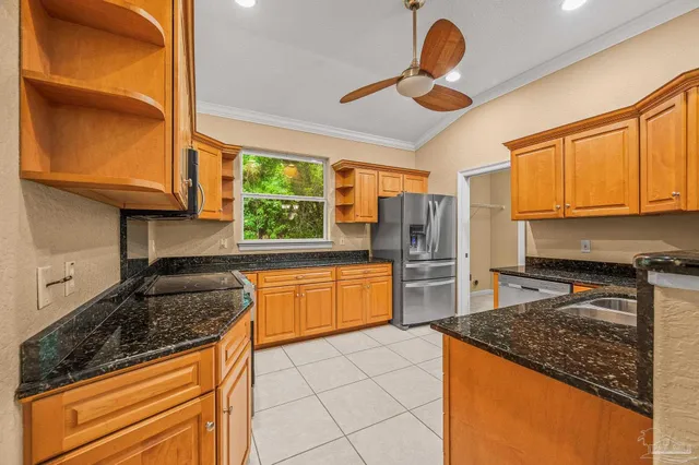 a kitchen with stainless steel appliances granite countertop a stove a sink and a refrigerator