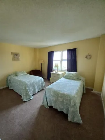 a bedroom with two beds and painting on the wall