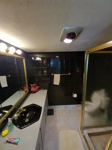 a bathroom with a sink a toilet and a shower