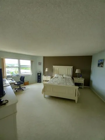 a bedroom with furniture and a large window