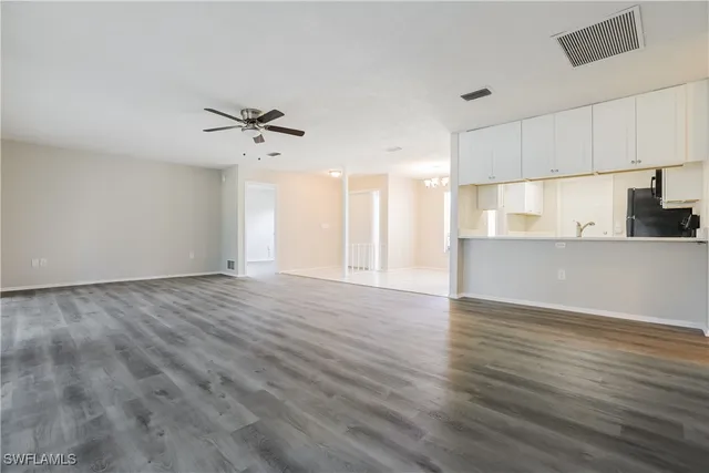 wooden floor in an empty room with a kitchen