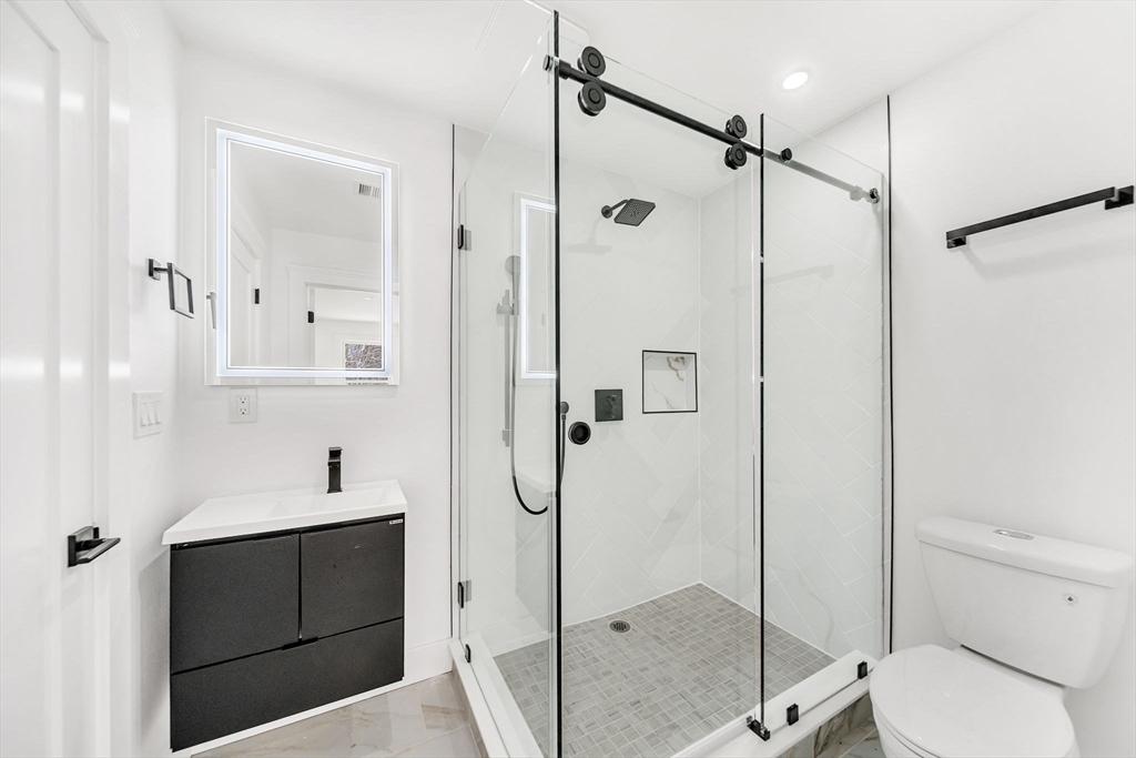 1 Sunnyside Avenue Wellesley, MA 02482 - Photo 18 of 30 a bathroom with a shower sink vanity and mirror