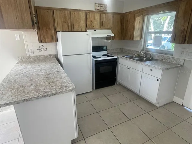 a kitchen with a stove a refrigerator and a sink