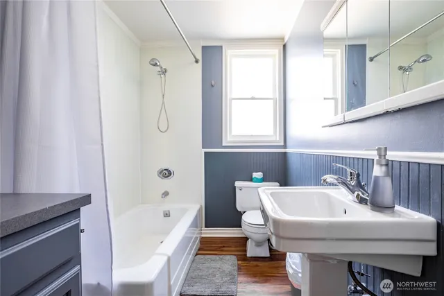 a bathroom with a tub sink and mirror