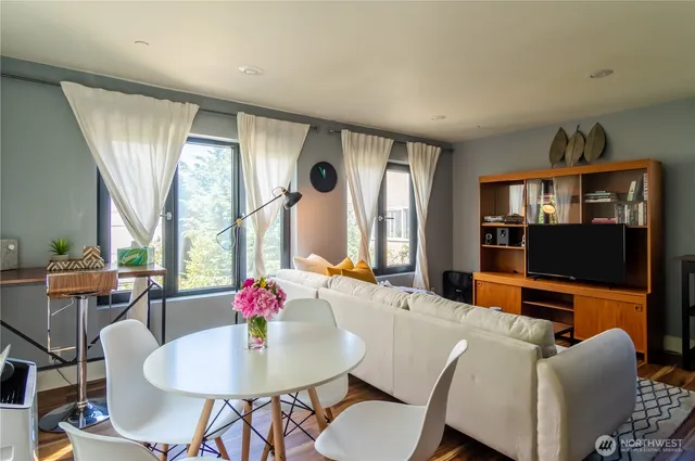 a dining room with furniture a rug and a flat screen tv
