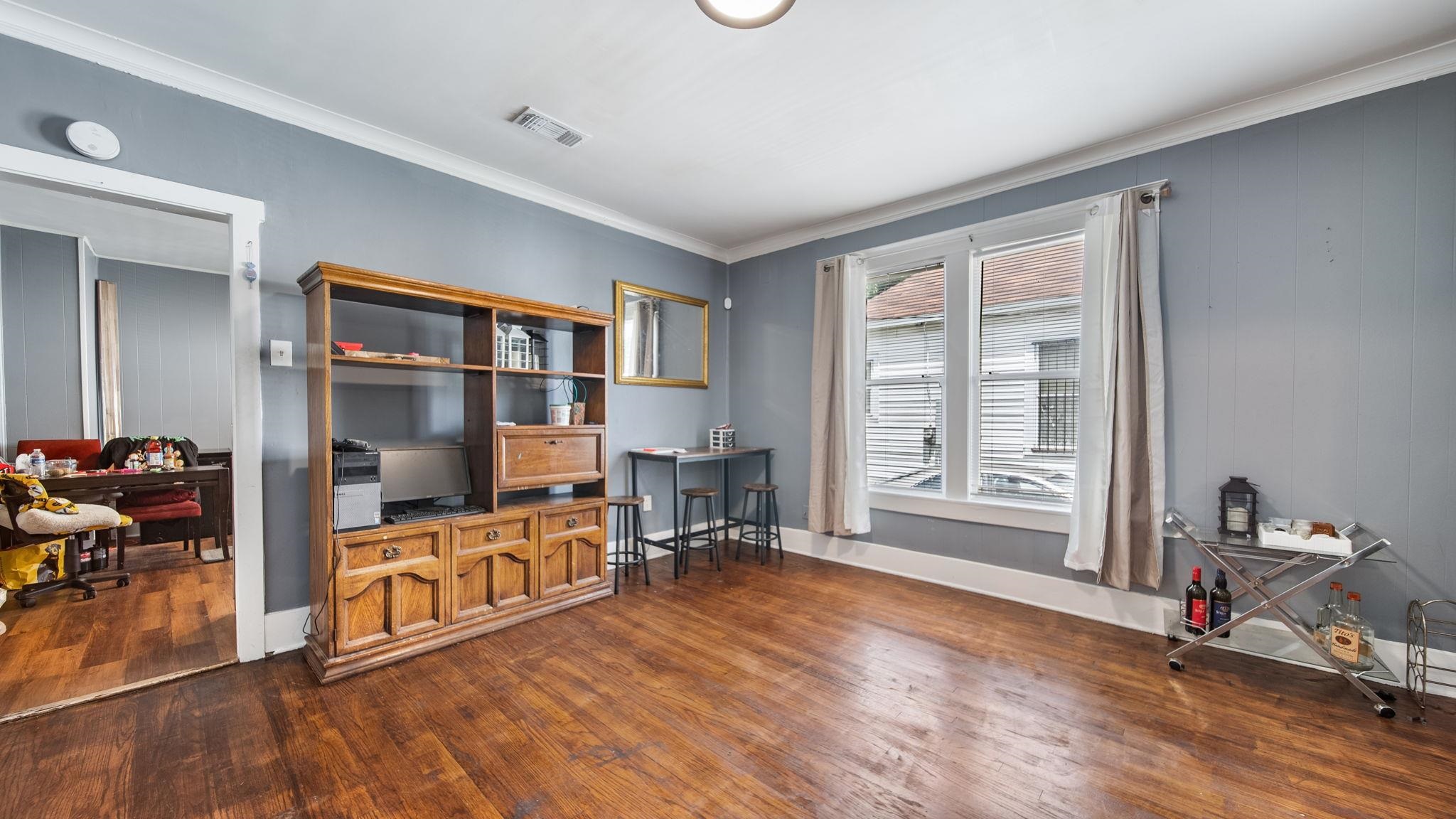 659 Decatur Street Memphis, TN 38107 - Photo 8 of 24 Spacious room featuring wood-finish flooring, light gray walls, white baseboards, and crown molding