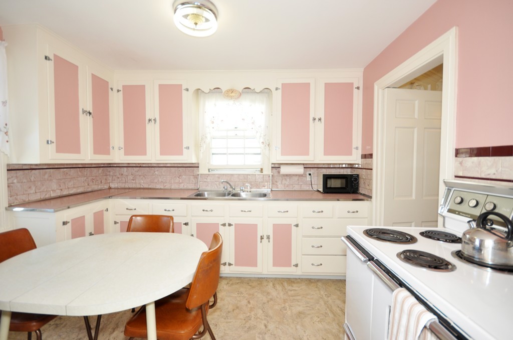 22 Bates Road Arlington, MA 02474 - Photo 14 of 30 a kitchen with stainless steel appliances granite countertop a stove a sink dishwasher and microwave with wooden floor