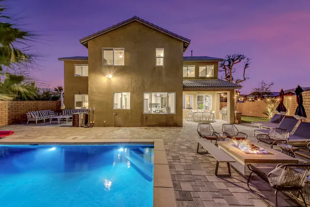 a view of a house with swimming pool and sitting area
