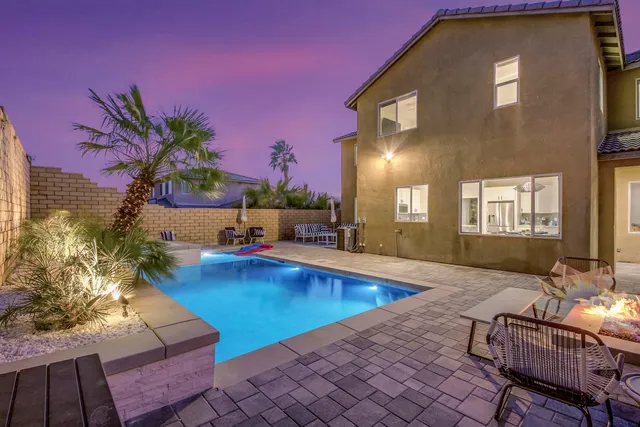 a front view of a house with a garden and trees