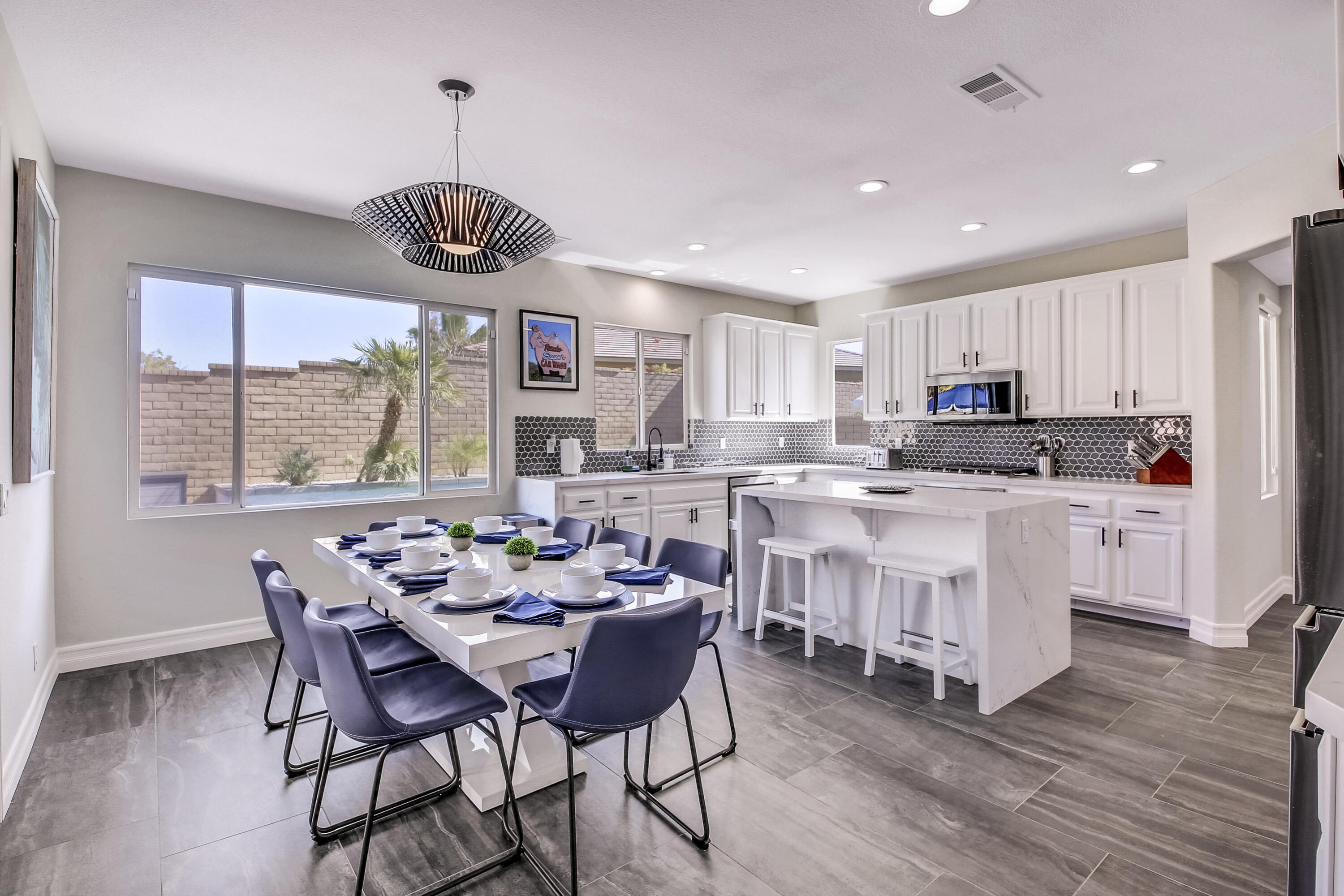 42942 Del Lago Court Indio, CA 92203 - Photo 10 of 75 a kitchen with stainless steel appliances granite countertop a stove a refrigerator a kitchen island with a dining table and chairs