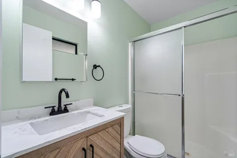 a bathroom with a sink a toilet and a mirror