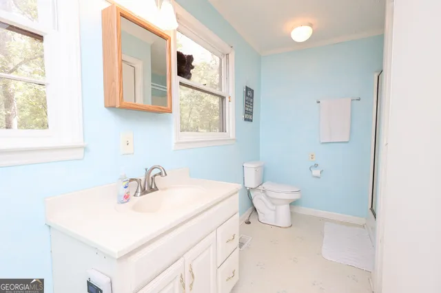 a bathroom with a sink a toilet and a window