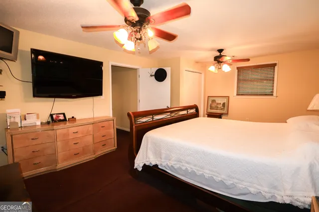 a spacious bedroom with a bed and a flat screen tv