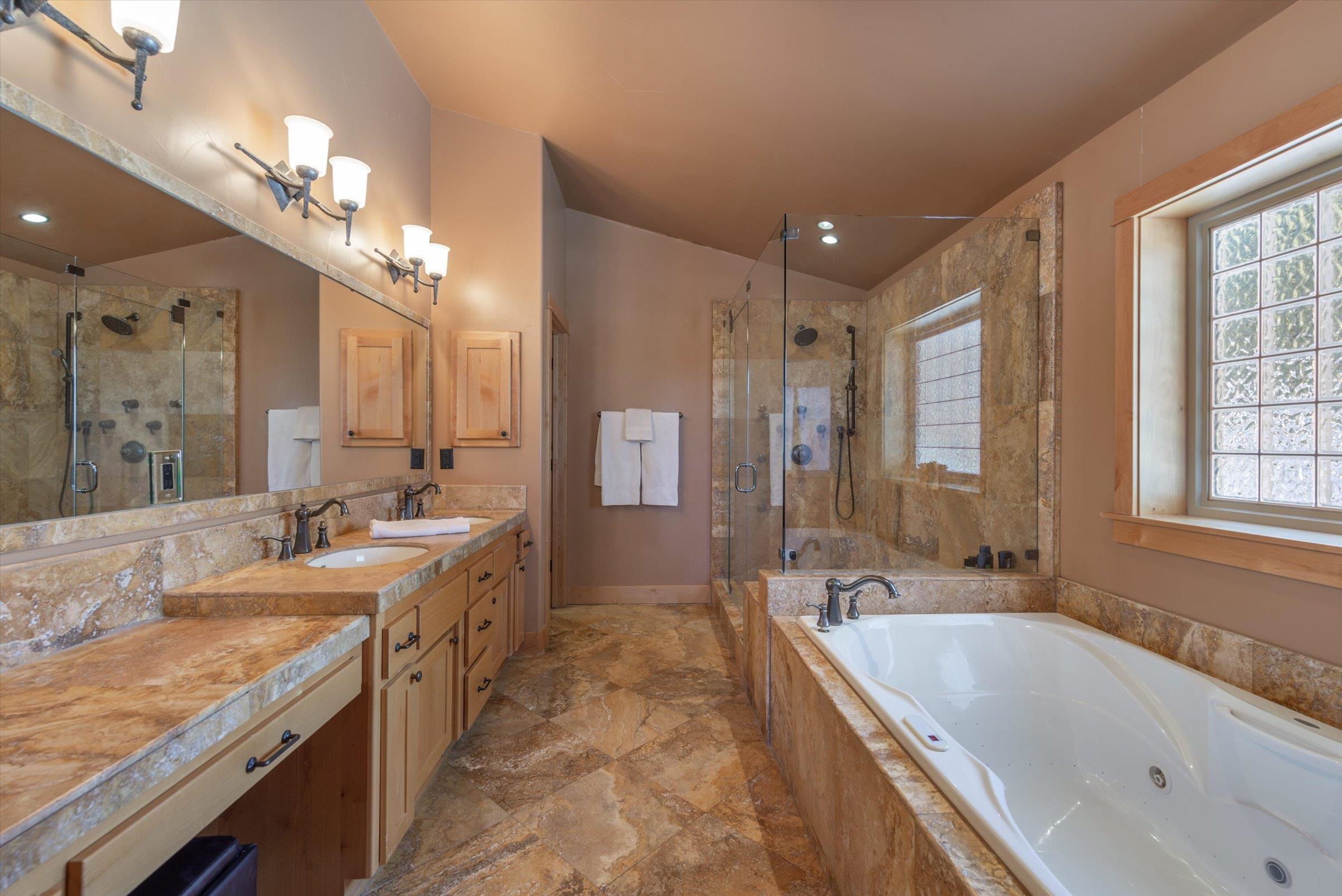 12968 Solvang Way Truckee, CA 96161 - Photo 9 of 21 a large bathroom with a granite countertop tub a double vanity sink a vanity and a large mirror