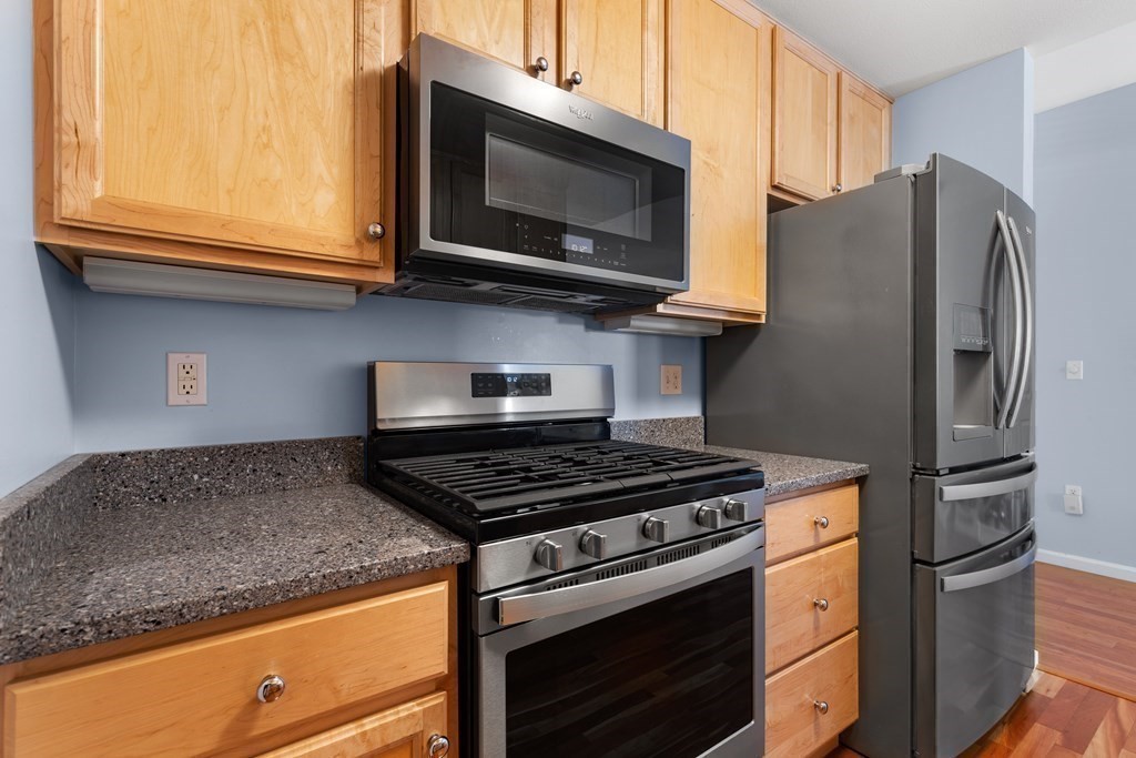 36 Village Road, Unit 306 Middleton, MA 01949 - Photo 12 of 38 a kitchen with stainless steel appliances granite countertop a stove microwave and refrigerator