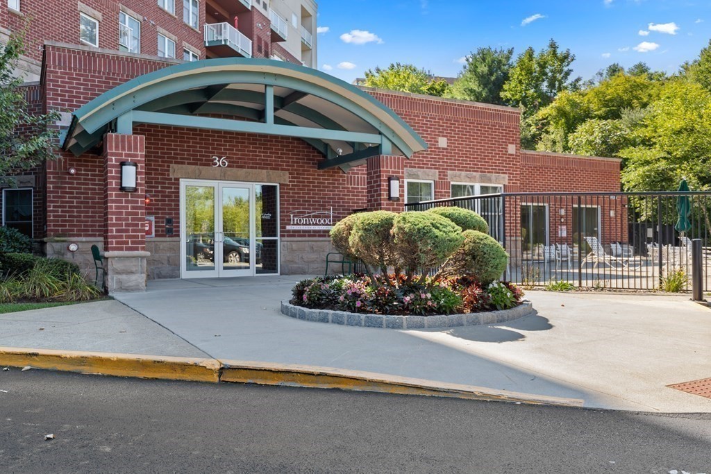 36 Village Road, Unit 306 Middleton, MA 01949 - Photo 3 of 38 a front view of a house with a yard and potted plants