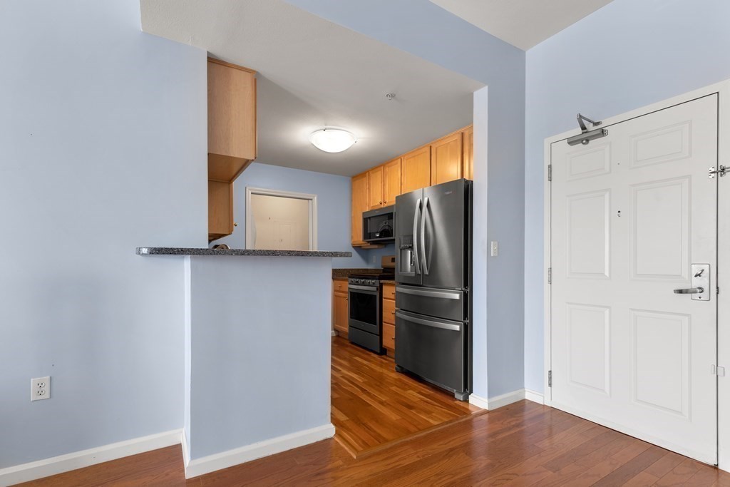36 Village Road, Unit 306 Middleton, MA 01949 - Photo 9 of 38 a view of a kitchen with a sink refrigerator and wooden floor