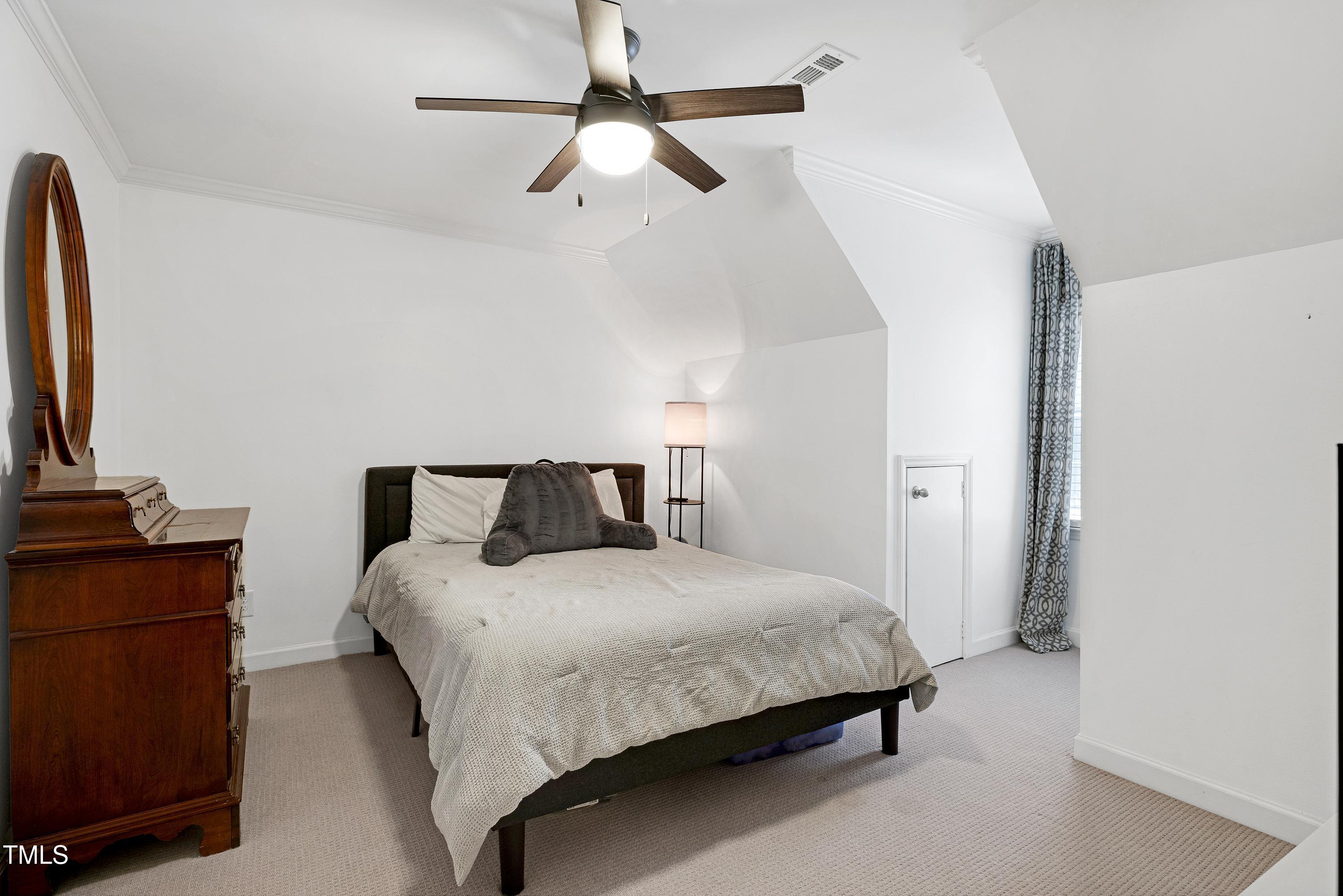 608 Misty Isle Place Raleigh, NC 27615 - Photo 54 of 75 a bedroom with a bed dresser and a flat tv screen