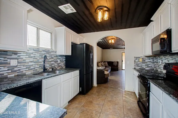 a kitchen with stainless steel appliances kitchen island granite countertop a stove refrigerator and microwave