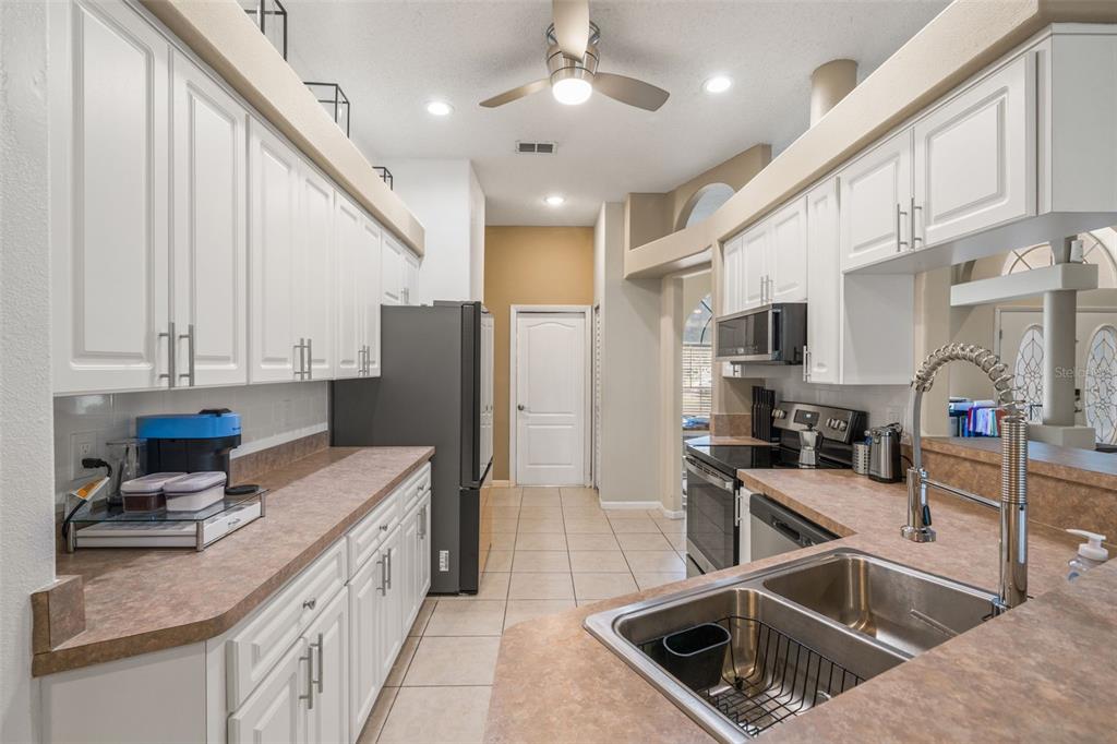 11128 Lomita Wren Road Weeki Wachee, FL 34614 - Photo 13 of 39 a kitchen that has a lot of cabinets and refrigerator