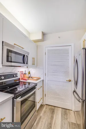 a kitchen with stainless steel appliances a stove microwave and refrigerator