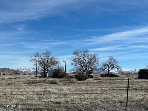 a view of a dry yard with wooden fence