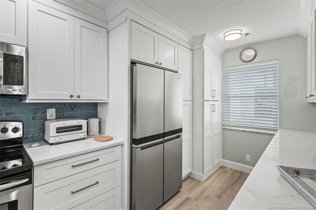 6082 Southeast Landing Way, Unit 7 Stuart, FL 34997 - Photo 8 of 36 Full Laundry is disguised in the back cabinet