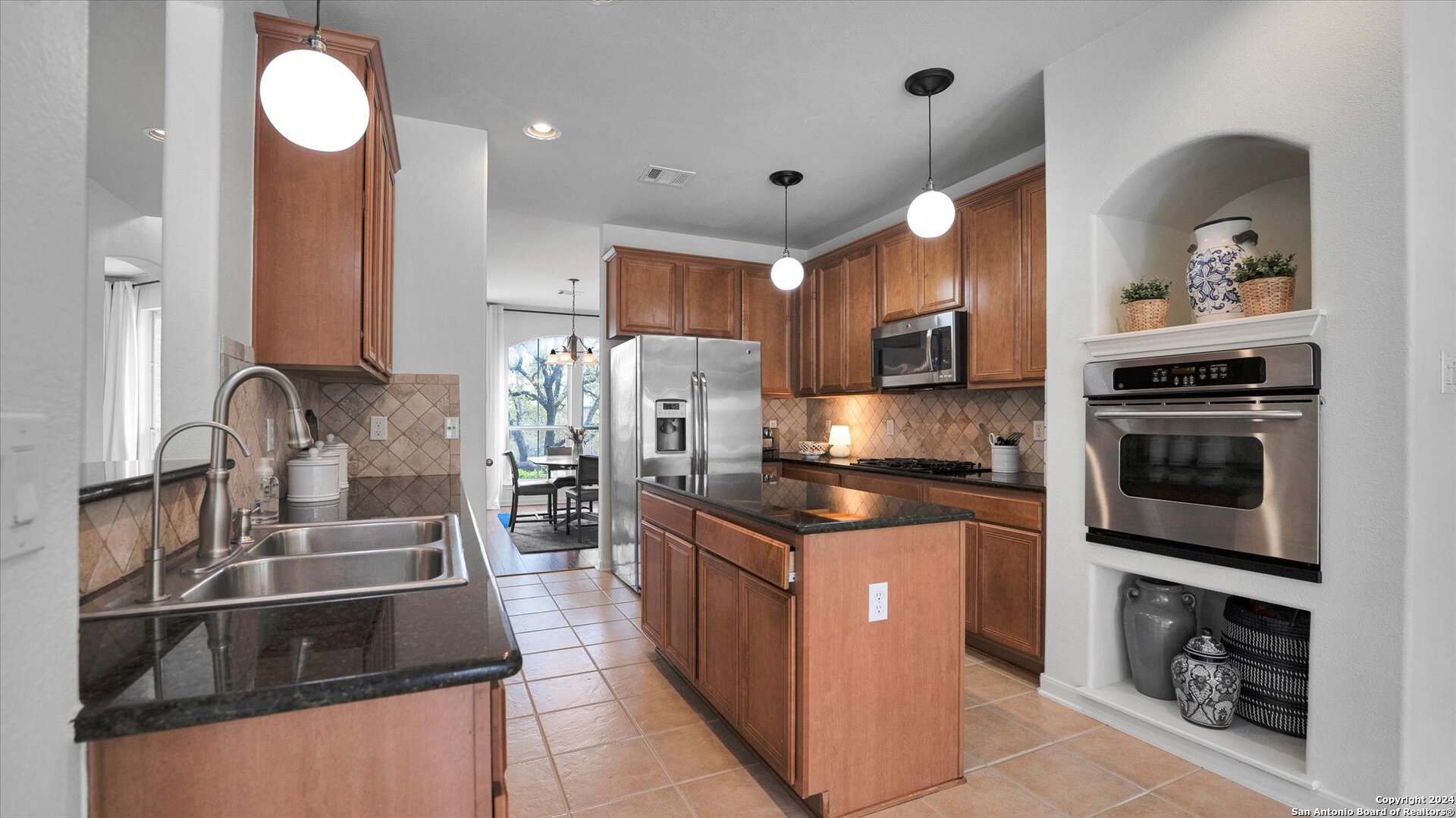 a kitchen with stainless steel appliances granite countertop a sink stove and refrigerator