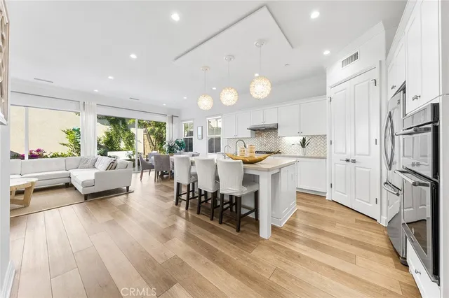 a large kitchen with stainless steel appliances kitchen island a large counter top and a wooden floors