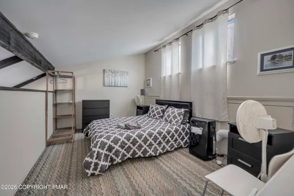 a bedroom with a bed flat screen tv and a window