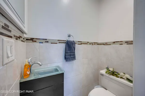 a bathroom with a granite countertop sink a toilet and shower