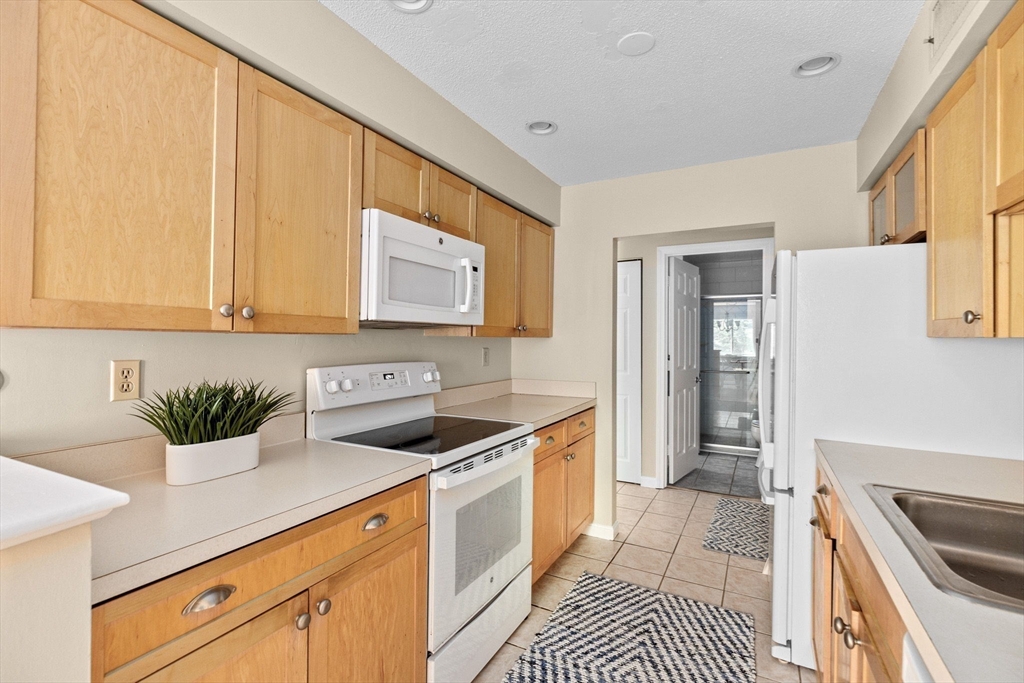 4 Beal's Cove Road, Unit B Hingham, MA 02043 - Photo 4 of 16 a kitchen with stainless steel appliances a sink a stove a refrigerator and cabinets