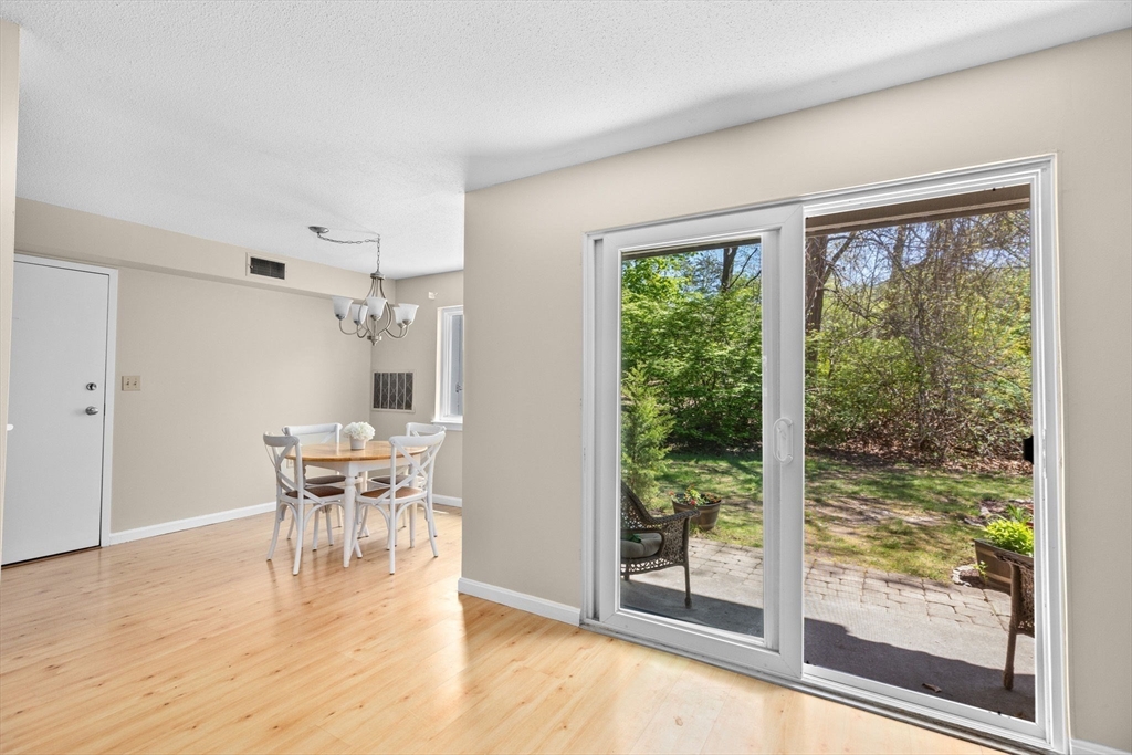 4 Beal's Cove Road, Unit B Hingham, MA 02043 - Photo 5 of 16 a dining room with wooden floor a glass table and a large window