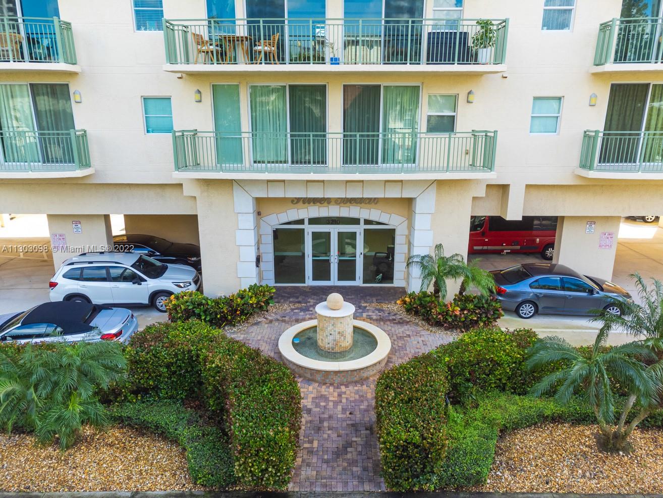 3210 Northeast 5th Street, Unit 203 Pompano Beach, FL 33062 - Photo 13 of 34 a front view of a house with yard and outdoor seating