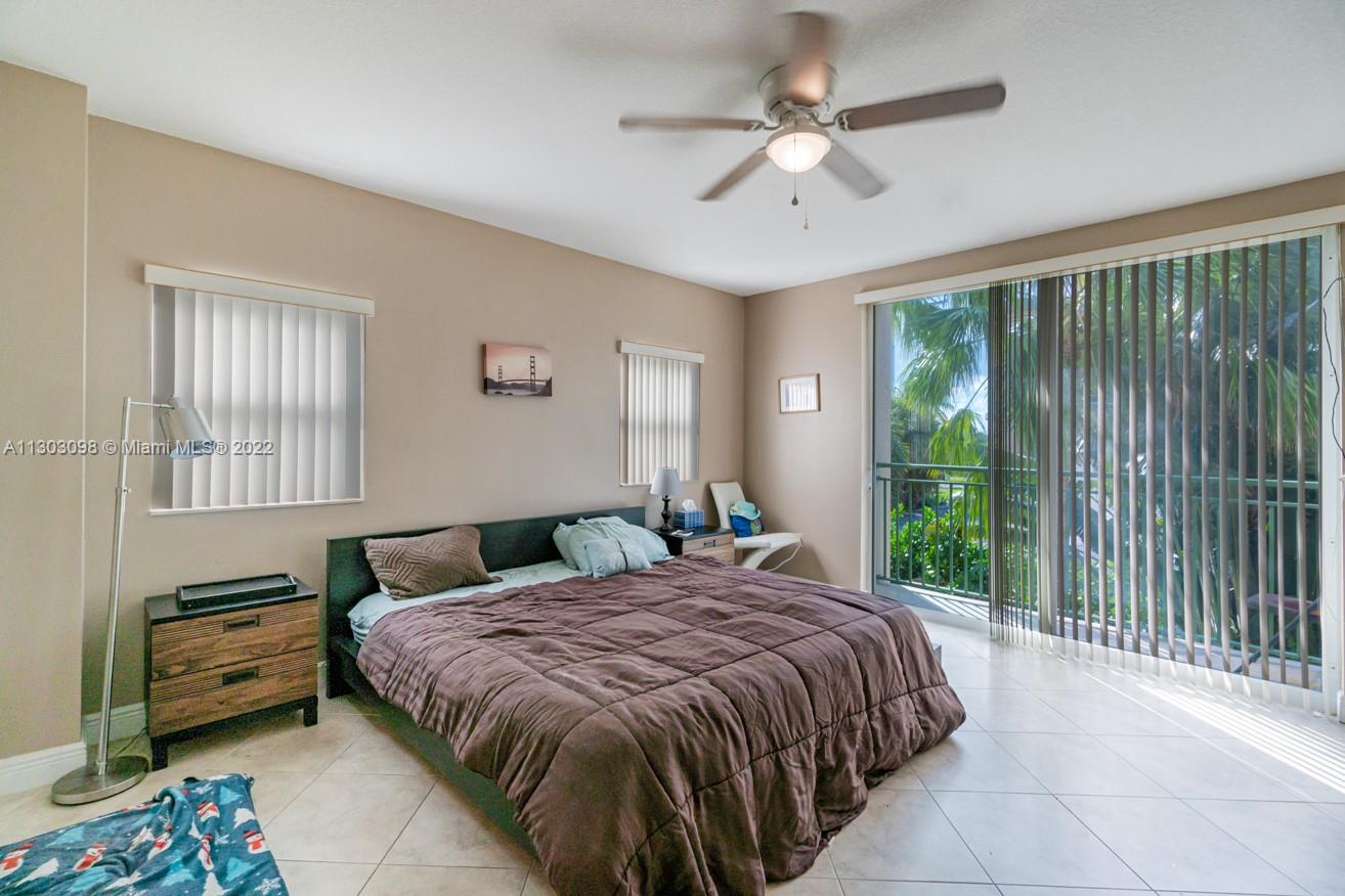 3210 Northeast 5th Street, Unit 203 Pompano Beach, FL 33062 - Photo 29 of 34 a bedroom with a bed and a chandelier