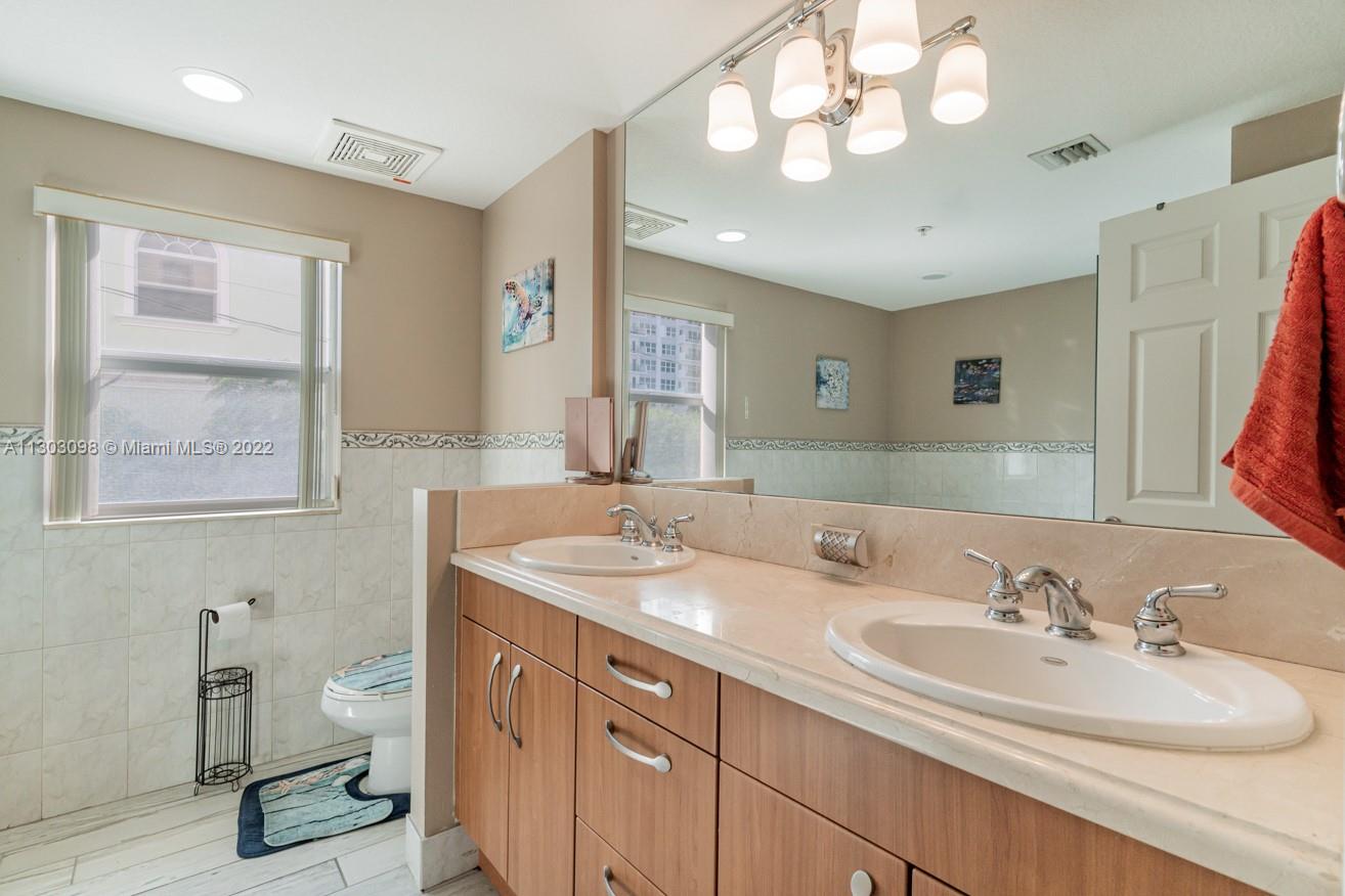 3210 Northeast 5th Street, Unit 203 Pompano Beach, FL 33062 - Photo 33 of 34 a bathroom with a sink a vanity and a mirror