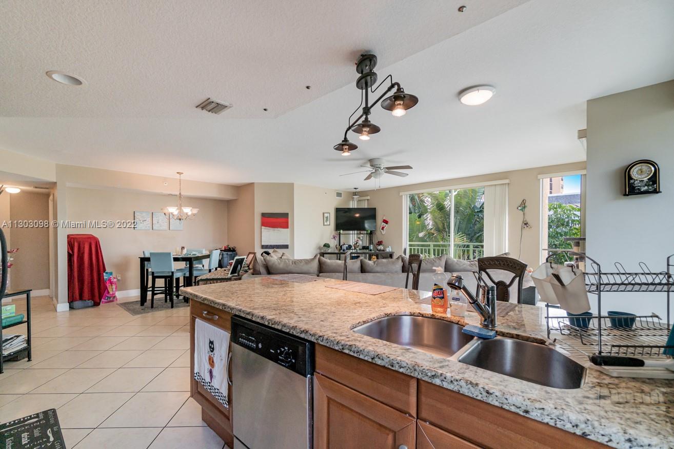 3210 Northeast 5th Street, Unit 203 Pompano Beach, FL 33062 - Photo 4 of 34 a kitchen with stainless steel appliances granite countertop a sink and a refrigerator