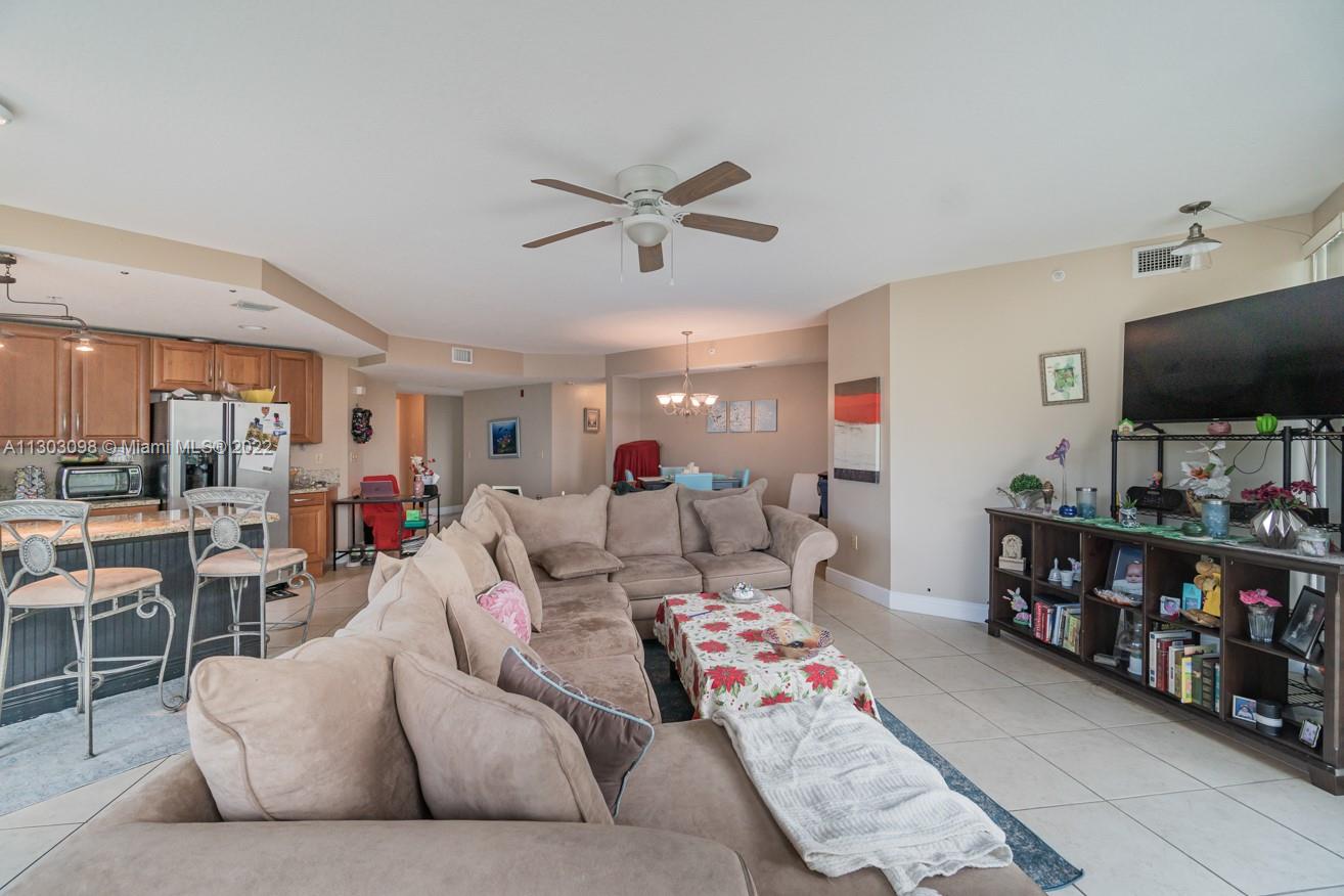 3210 Northeast 5th Street, Unit 203 Pompano Beach, FL 33062 - Photo 8 of 34 a living room with furniture and a flat screen tv