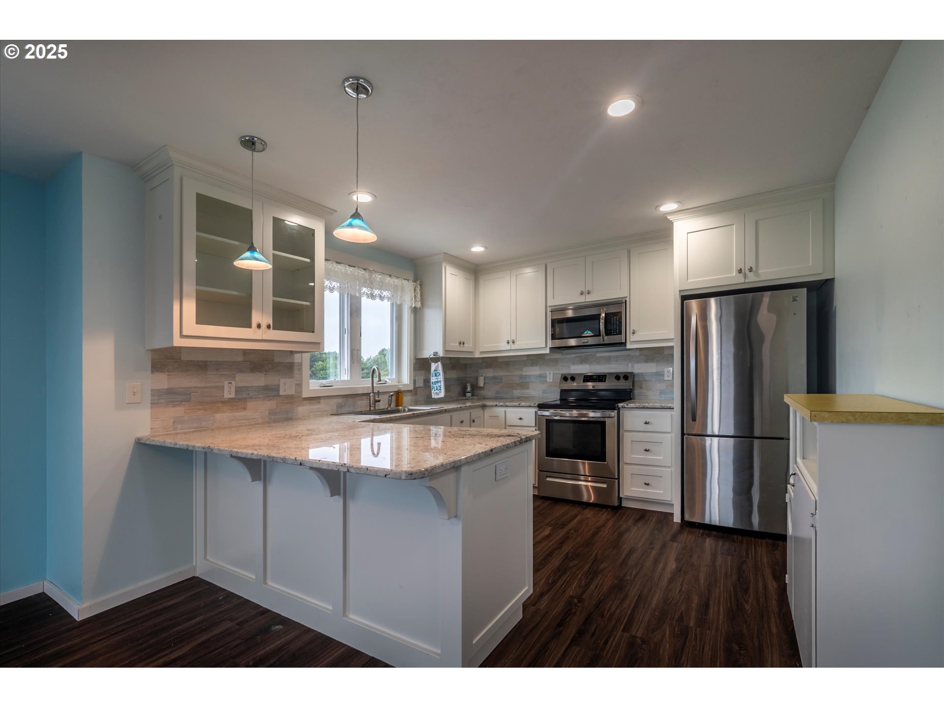 3145 Periwinkle Lane Southwest Bandon, OR 97411 - Photo 12 of 26 a kitchen with stainless steel appliances granite countertop a refrigerator a sink dishwasher a stove and white countertops with wooden floor