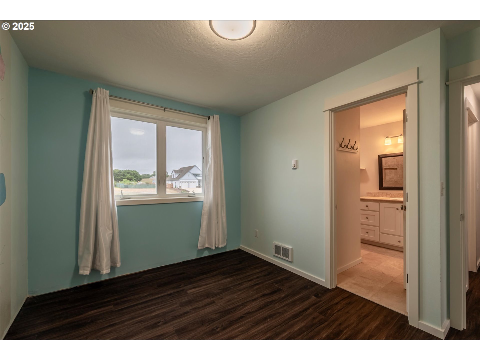 3145 Periwinkle Lane Southwest Bandon, OR 97411 - Photo 18 of 26 a view of an empty room with wooden floor and a window