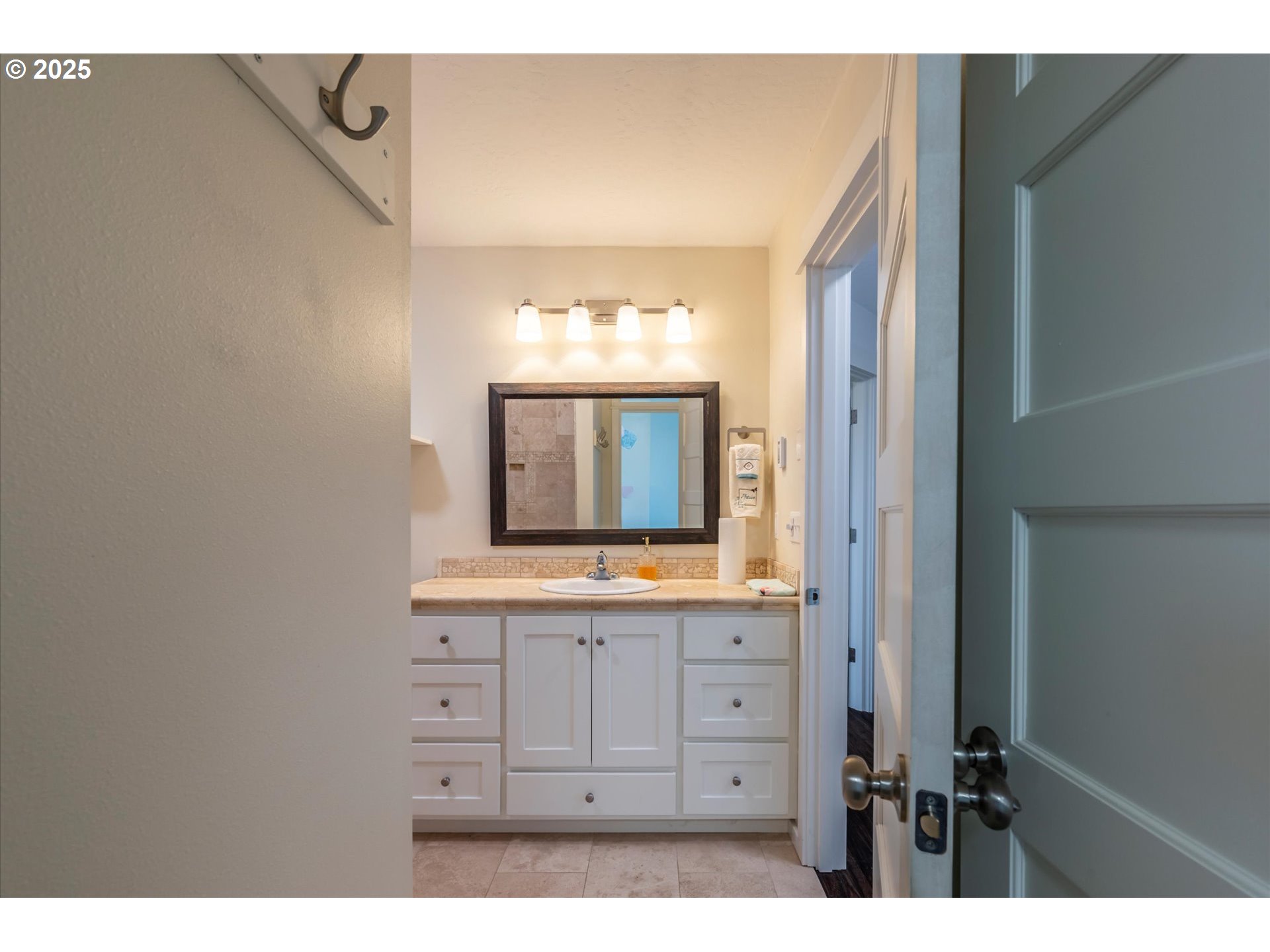3145 Periwinkle Lane Southwest Bandon, OR 97411 - Photo 21 of 26 a bathroom with a sink a mirror and a light fixture a sink