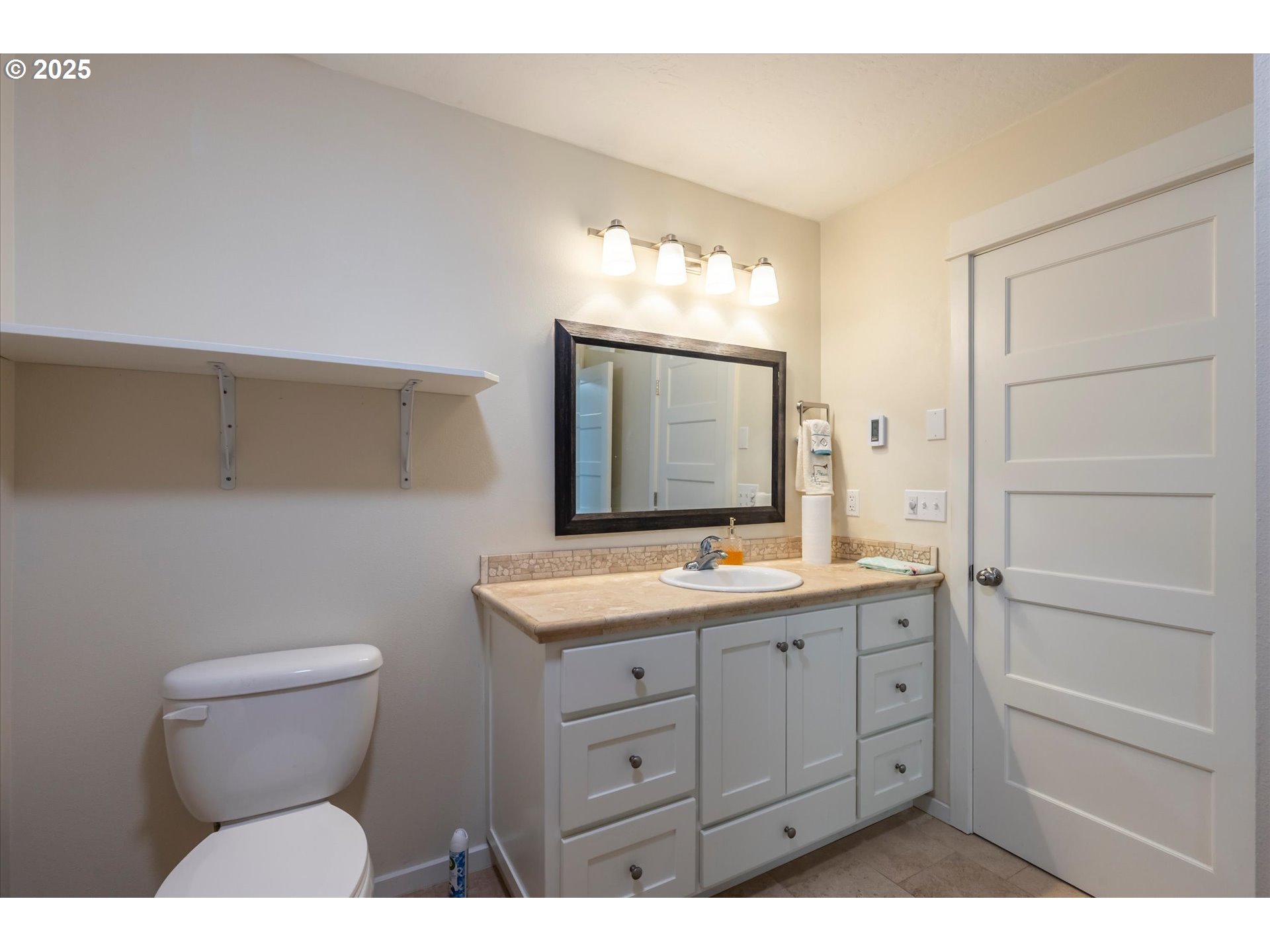 3145 Periwinkle Lane Southwest Bandon, OR 97411 - Photo 23 of 26 a bathroom with a toilet sink and mirror