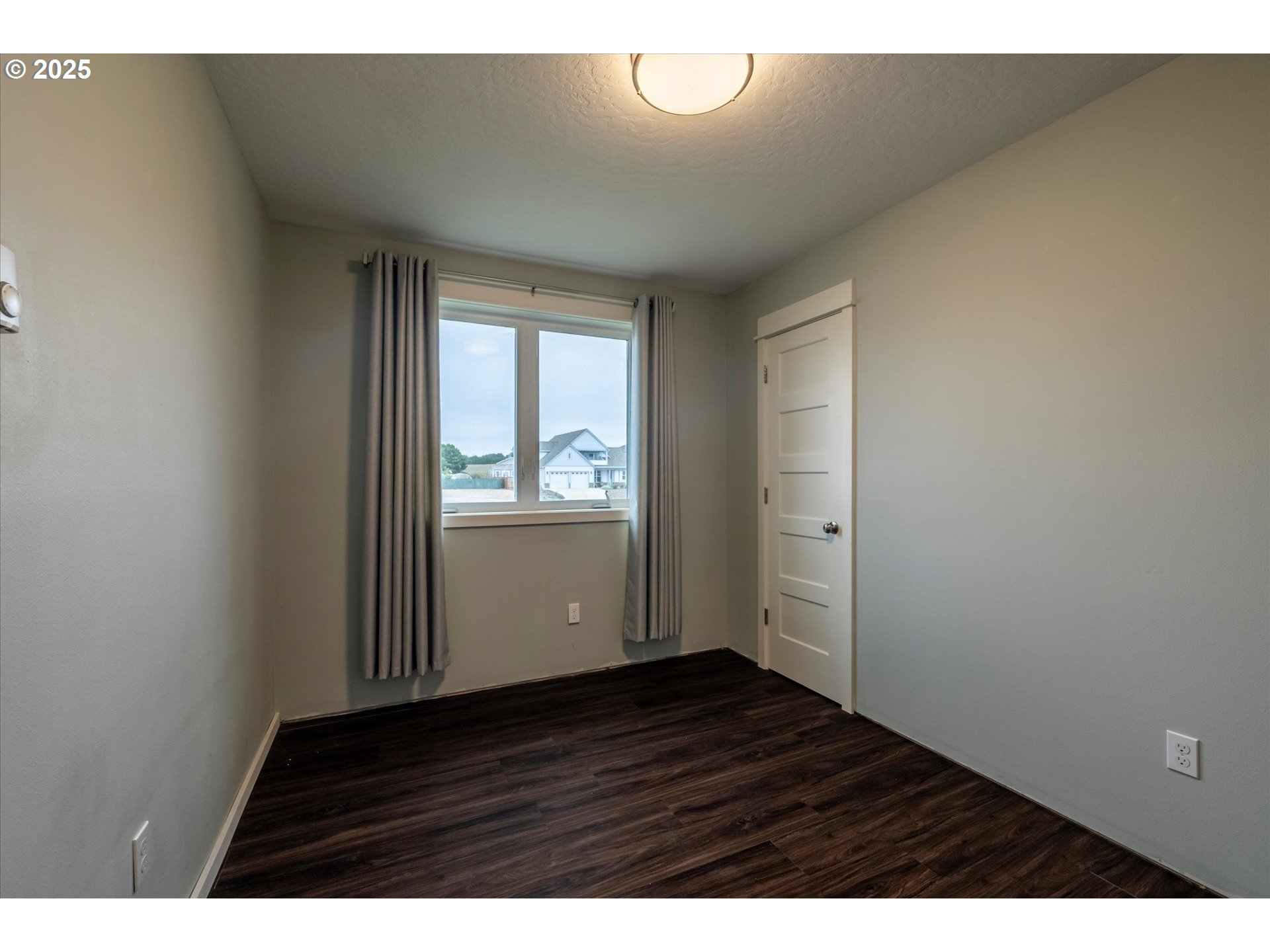 3145 Periwinkle Lane Southwest Bandon, OR 97411 - Photo 25 of 26 a view of an empty room with wooden floor and a window