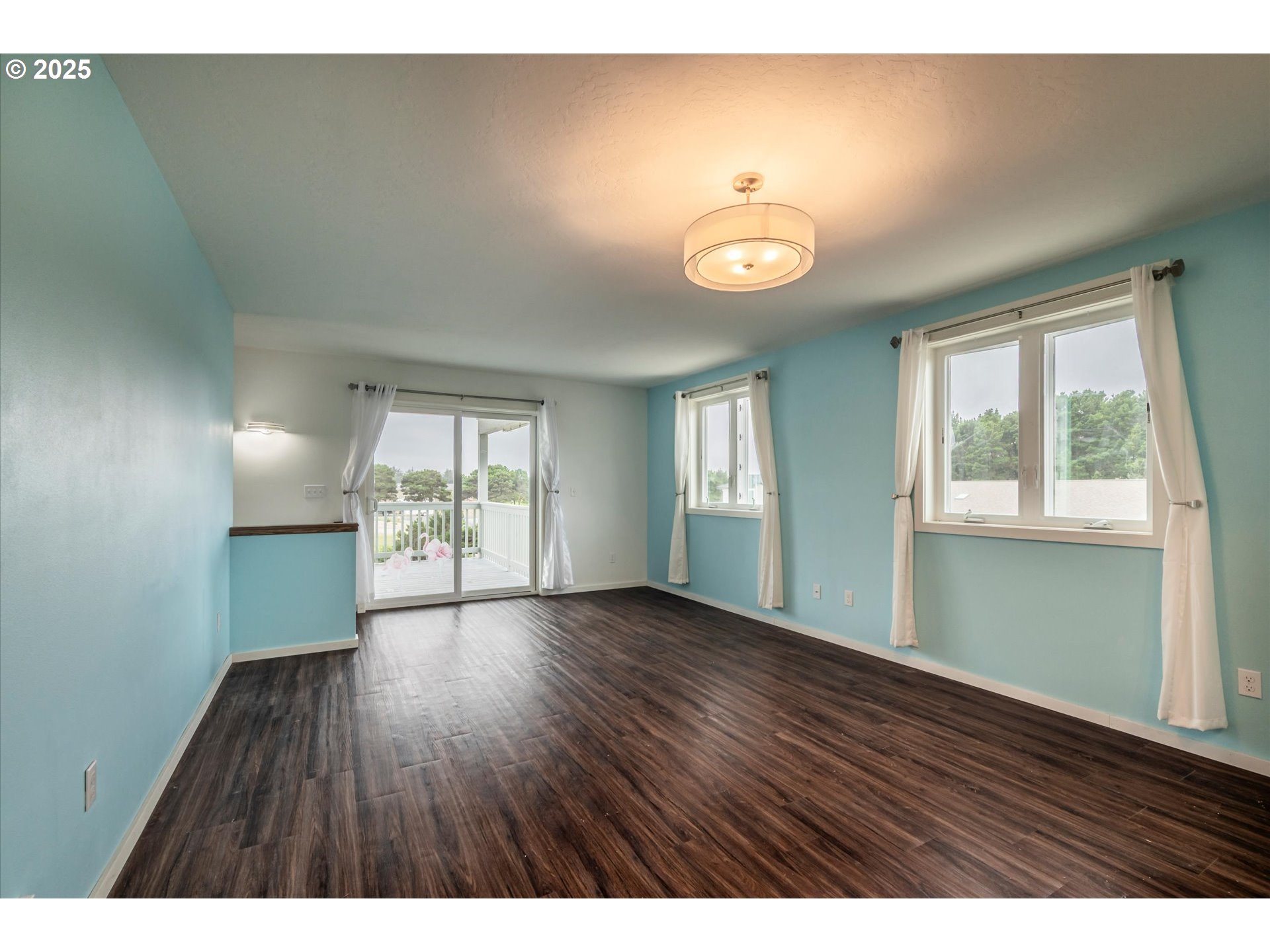 3145 Periwinkle Lane Southwest Bandon, OR 97411 - Photo 5 of 26 a view of an empty room with wooden floor and a window